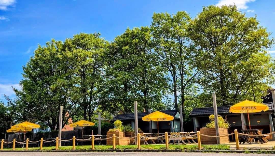The Wellington Inn beer garden in Wolviston with yellow parasols, picnic benches and mature trees